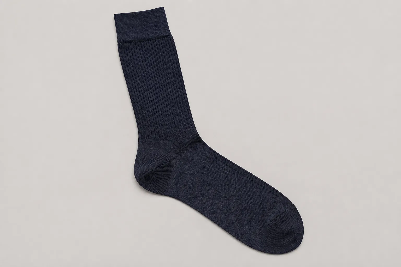 Fine-gauge ink-blue alpaca dress sock laid flat to show its cuff, leg, heel, toe, and sole